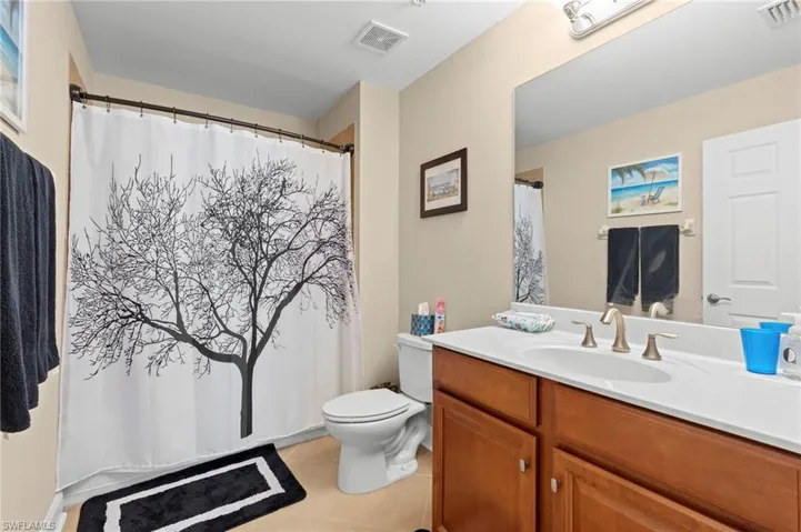 Full bath with light tile patterned floors, vanity, and a shower with curtain