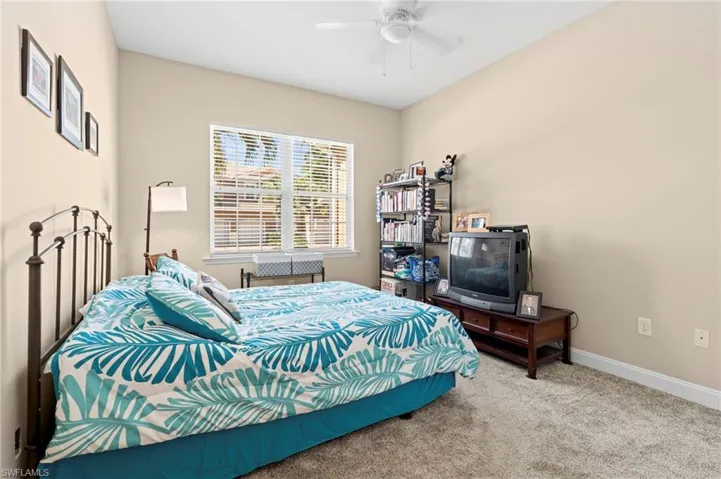 Carpeted bedroom featuring baseboards and a ceiling fan