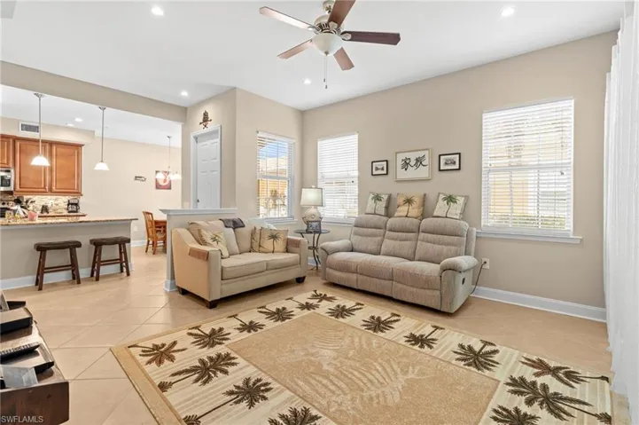 Living room with light tile patterned floors, recessed lighting, and a ceiling fan