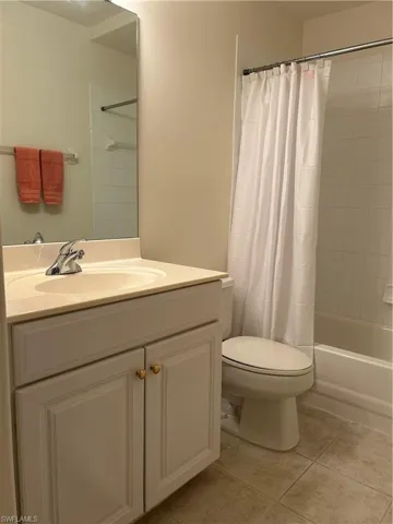 Full bathroom featuring tile flooring, toilet, vanity, and shower / bath combo
