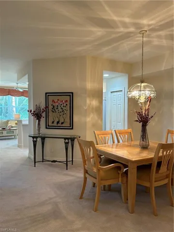 Dining space with a notable chandelier and carpet floors