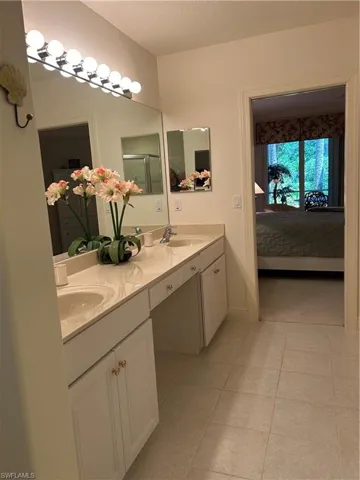Bathroom with a textured ceiling, tile flooring, double sink, and large vanity