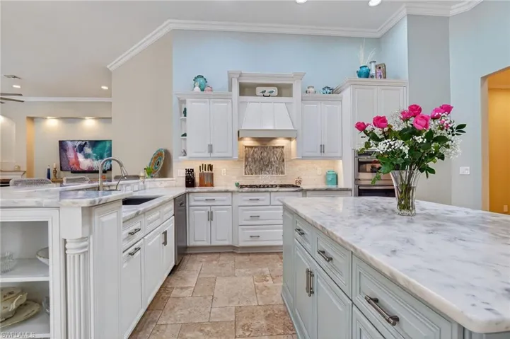 Kitchen featuring open shelves, light stone counters, white cabinetry, recessed lighting, and ornamental molding