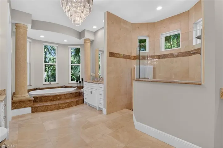 Full bathroom with vanity, plenty of natural light, a garden tub, and recessed lighting