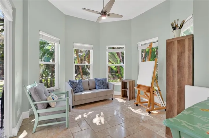 Sunroom / solarium with healthy amount of natural light, crown molding, and stone tile flooring
