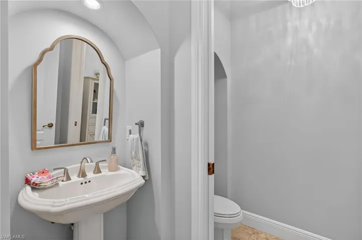 Bathroom featuring vaulted ceiling and toilet