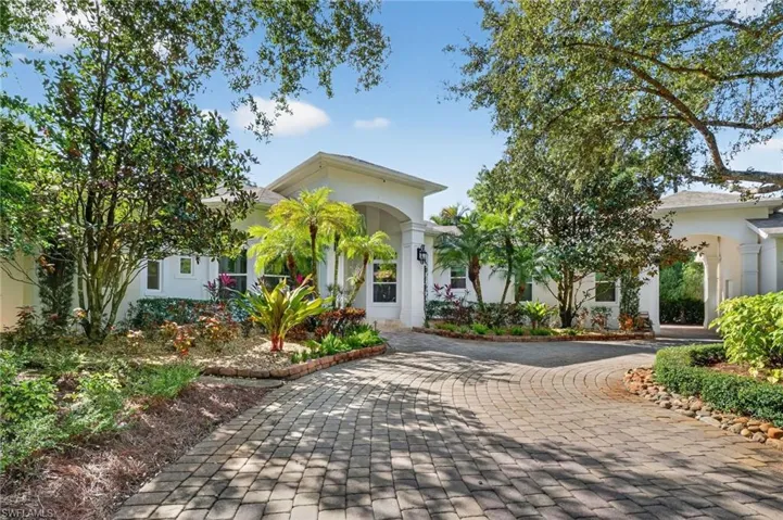 View of front of house with stucco siding and decorative driveway