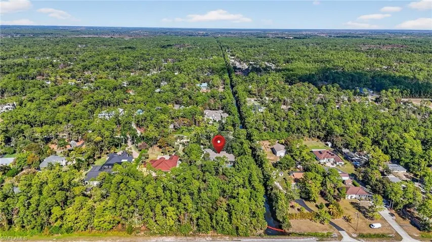 Aerial overview of property's location featuring a forest and nearby suburban area
