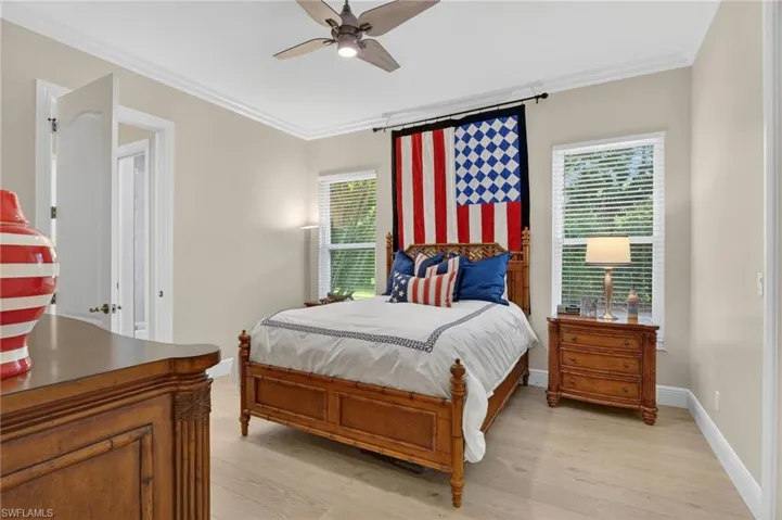 Bedroom featuring ornamental molding, light wood finished floors, and ceiling fan