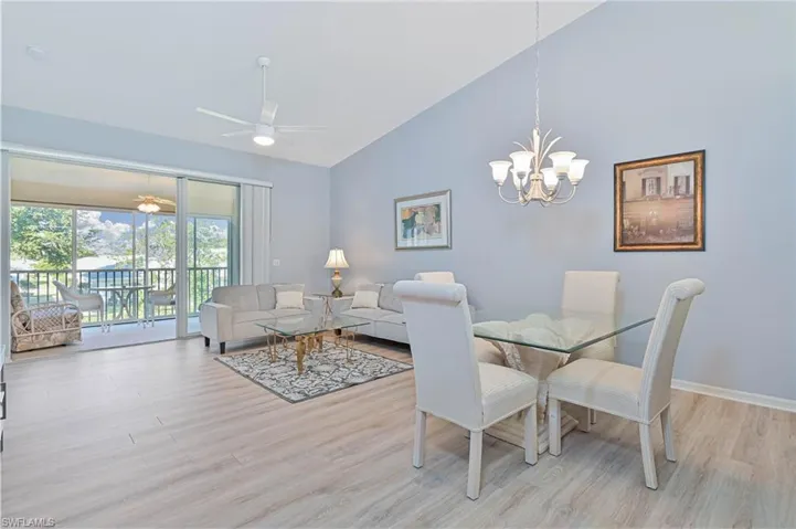 Dining space with a ceiling fan, lofted ceiling, light wood-style flooring, and suspended lighting