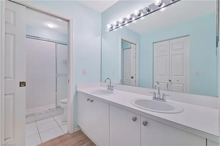 Bathroom with double vanity and a stall shower
