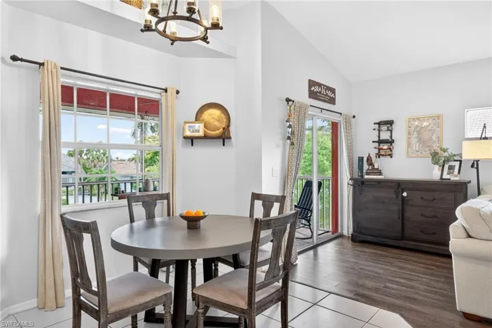 Dining area featuring a contemporary round table, four upholstered chairs, and a window with outdoor views