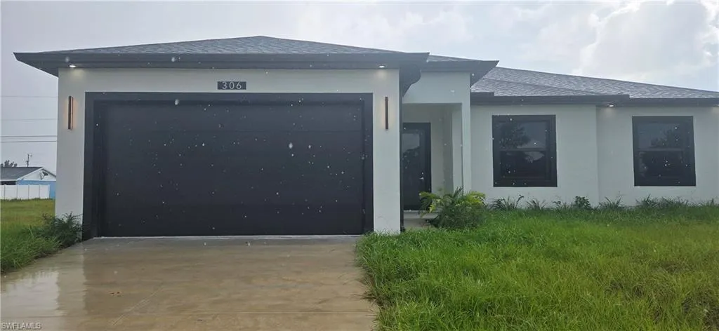 View of front of house featuring driveway, roof with shingles, a garage, and stucco siding