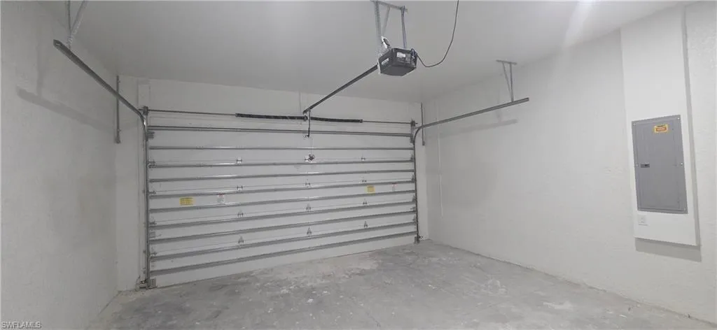 Garage with electric panel and a garage door opener