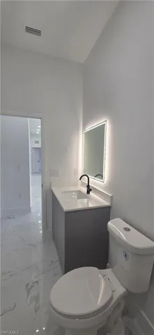 Bathroom with light marble finish flooring and vanity
