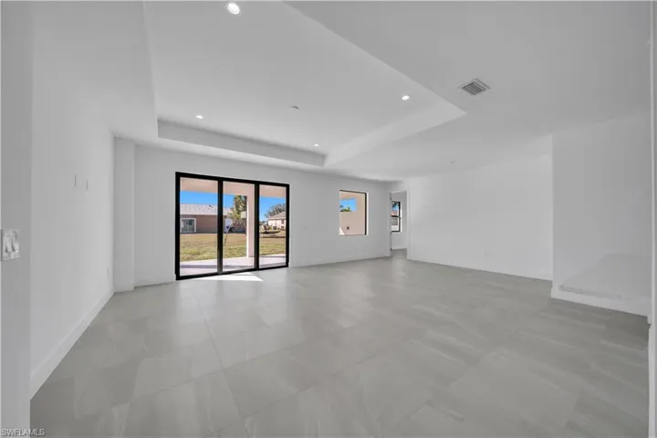 Unfurnished room featuring a tray ceiling and recessed lighting