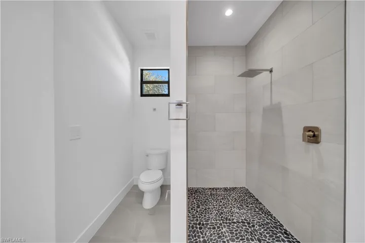 Bathroom with toilet and a tile shower