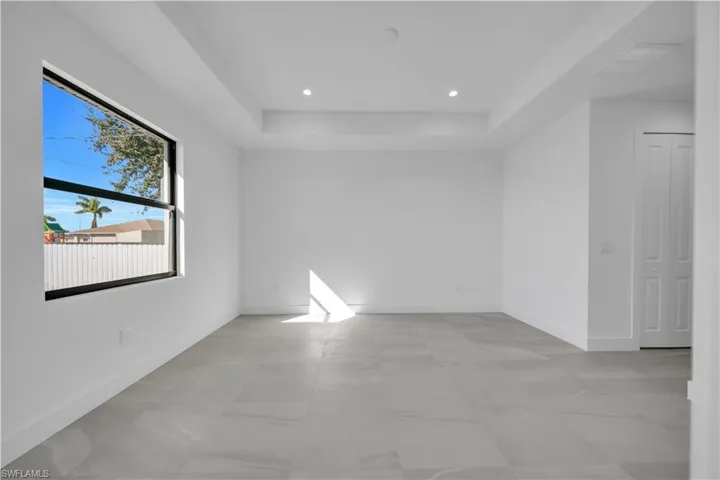 Spare room with recessed lighting and a raised ceiling