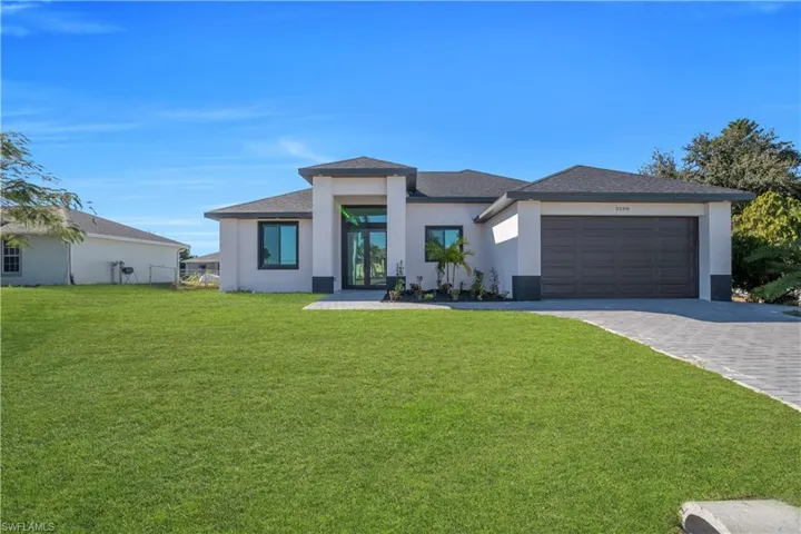 Prairie-style house with stucco siding, decorative driveway, an attached garage, and roof with shingles