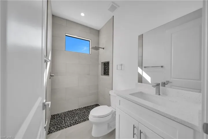 Full bathroom featuring a shower stall, vanity, and recessed lighting