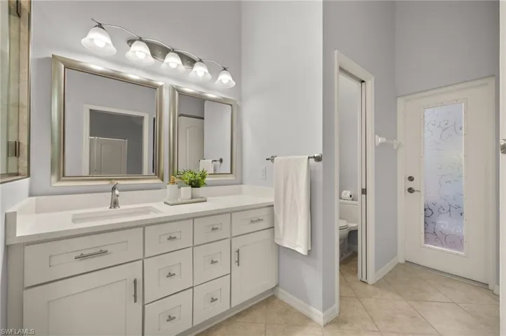 Bathroom with toilet, tile patterned flooring, and vanity