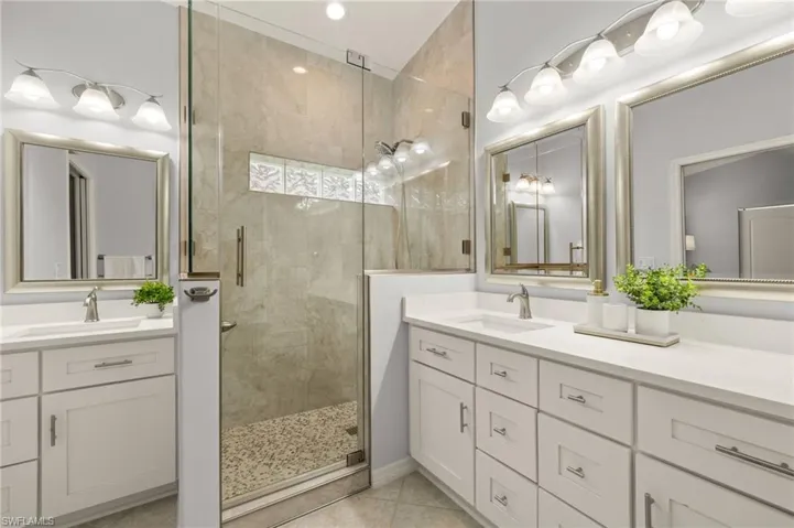 Bathroom featuring tile patterned floors, walk in shower, and vanity