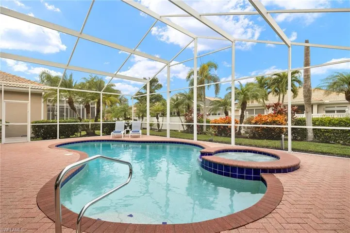 View of swimming pool with a lanai, a patio area, and an in ground hot tub