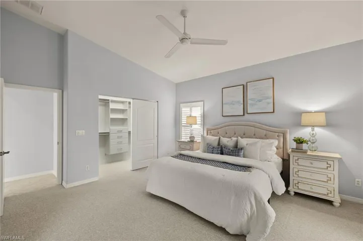 Carpeted bedroom featuring ceiling fan, a closet, and high vaulted ceiling