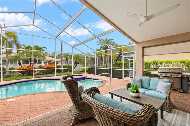 View of swimming pool featuring a lanai, grilling area, ceiling fan, a patio area, and an in ground hot tub