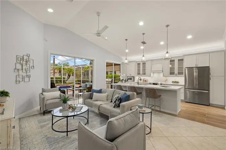 Tiled living room featuring vaulted ceiling, ceiling fan, crown molding, and sink
