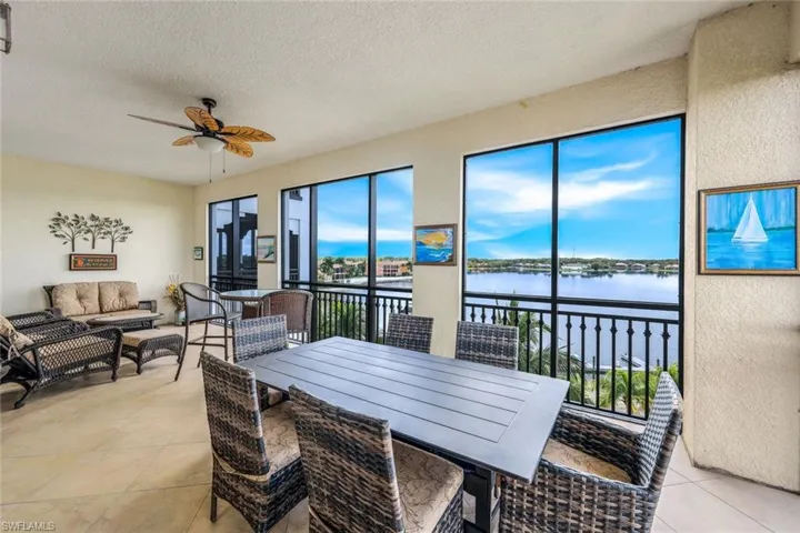 Lanai Dining space featuring a textured ceiling, beach and lake view, light tile patterned floors, and ceiling fan