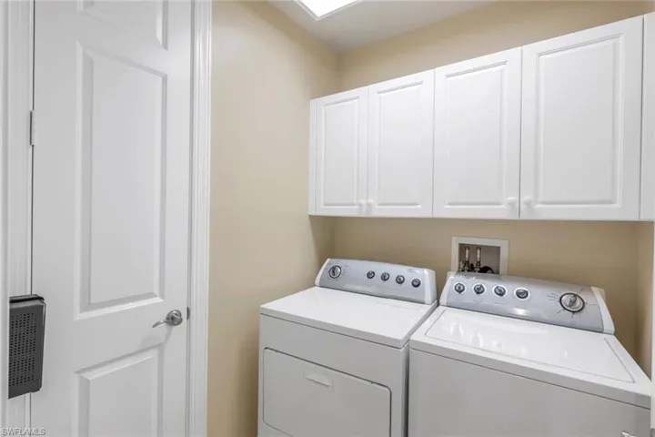 Laundry area with washing machine and dryer and cabinets