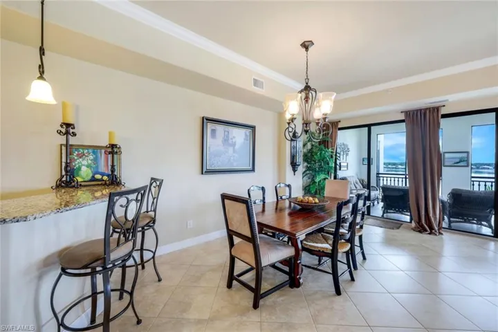 Dining area featuring a notable chandelier, ornamental molding, and light tile patterned floors