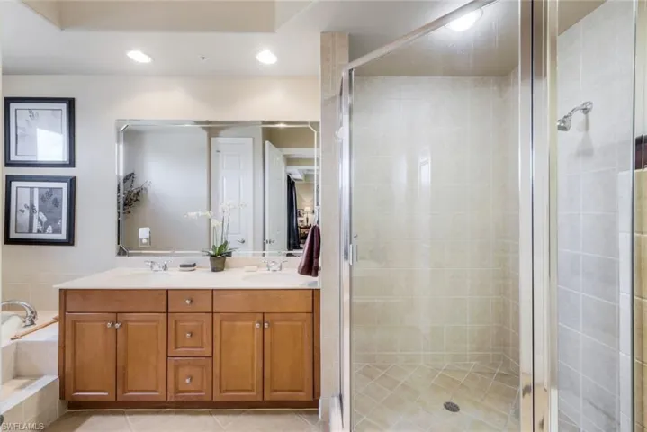 Master Suite Bathroom with dual vanity, tile patterned floors, andwalk in shower