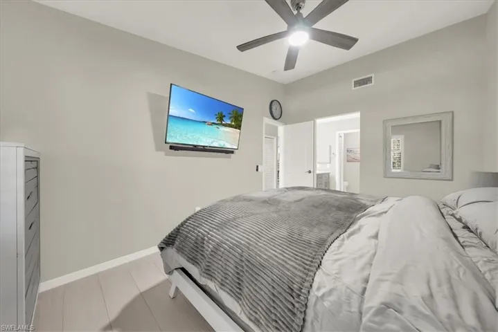 Bedroom featuring a ceiling fan and connected bathroom