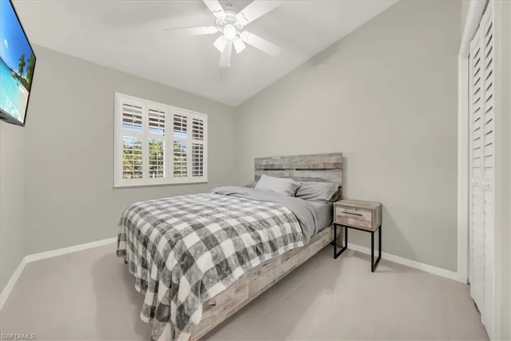 Bedroom with vaulted ceiling and a ceiling fan