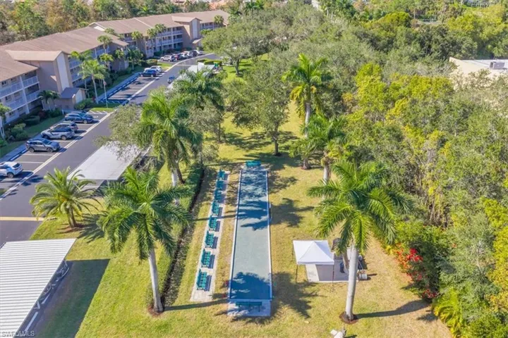Drone / aerial view of apartment complex / building and a tree filled landscape