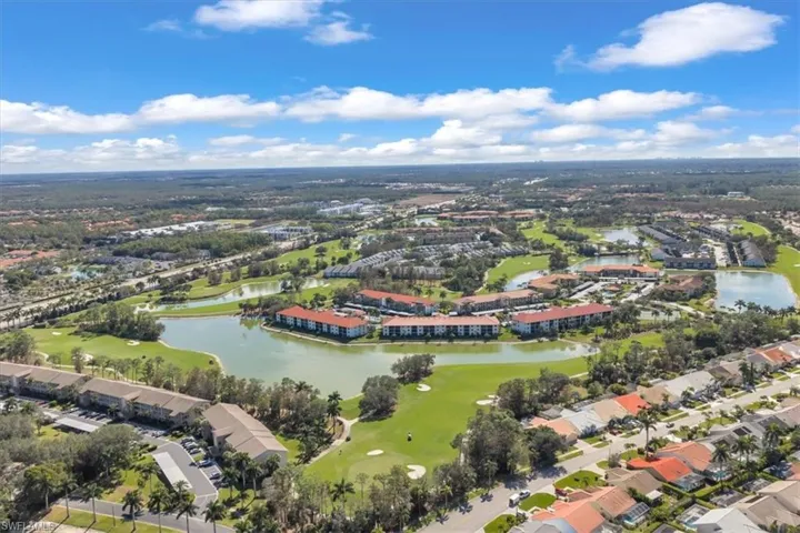 Aerial view of property's location featuring a local golf course, a large body of water, and nearby suburban area