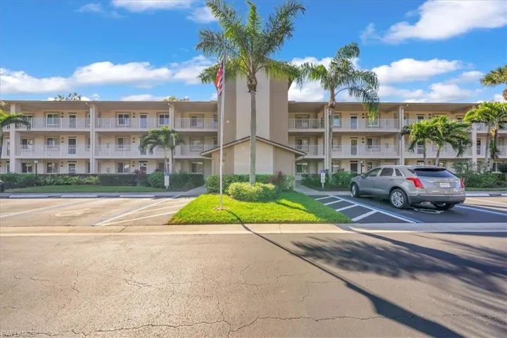View of apartment building / complex with uncovered parking