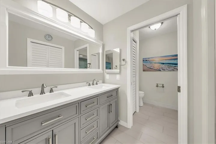 Full bath with double vanity and toilet