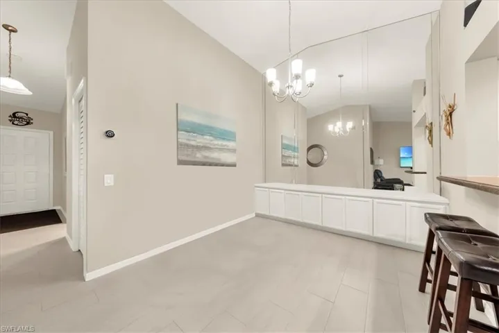 Bathroom featuring lofted ceiling, double vanity, and a chandelier