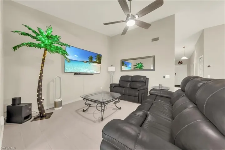 Living area featuring ceiling fan and high vaulted ceiling