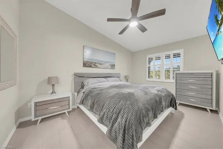 Bedroom with vaulted ceiling and a ceiling fan