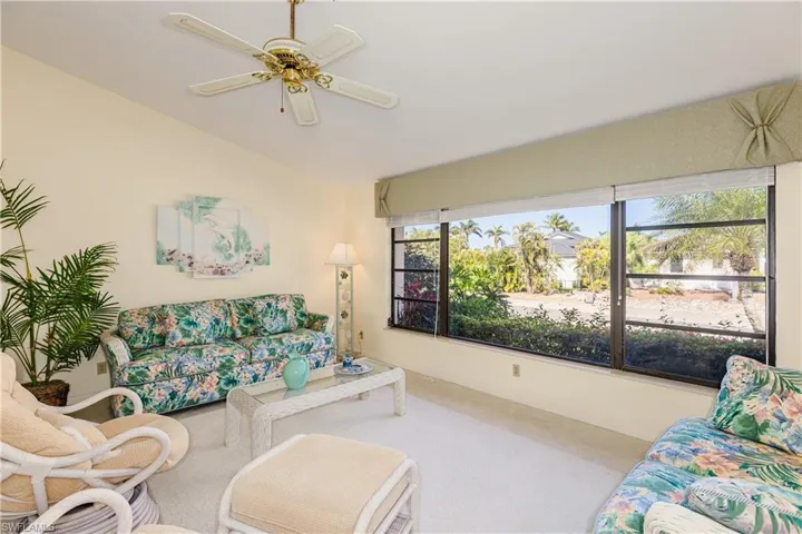 Living room with lofted ceiling and ceiling fan