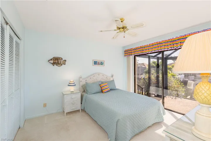 Bedroom with ceiling fan, light colored carpet, a closet, and access to outside