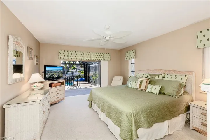 Bedroom with access to exterior, light colored carpet, and ceiling fan