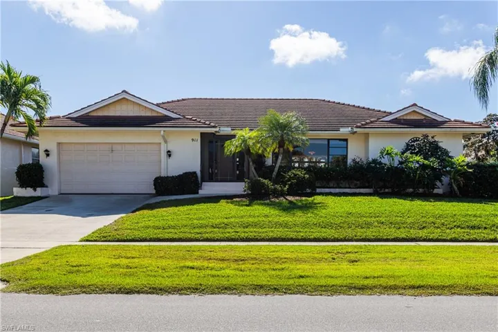 Ranch-style house featuring a garage and a front yard