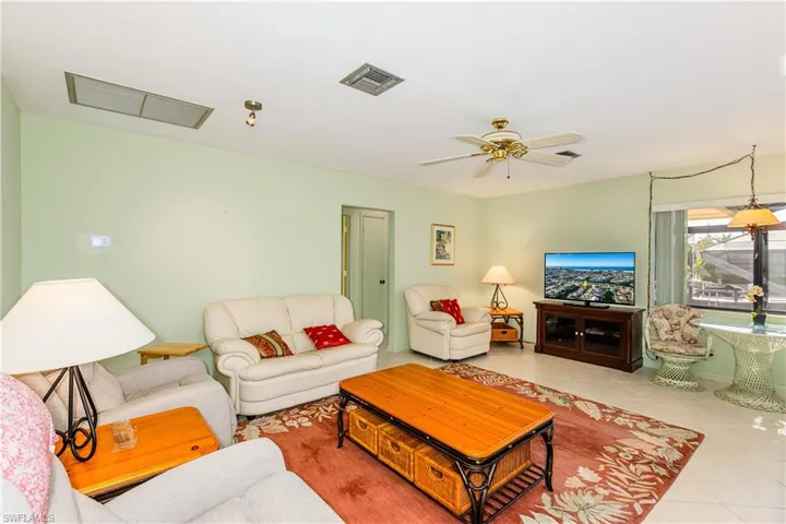 Living room with ceiling fan and light tile patterned floors
