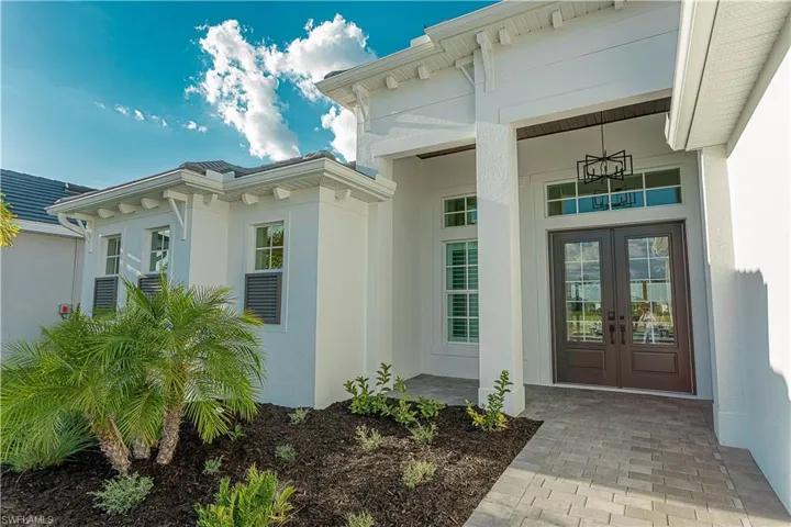 Doorway to property featuring stucco siding and French doors, chandelier installed with tongue and groove ceiling upgrade.