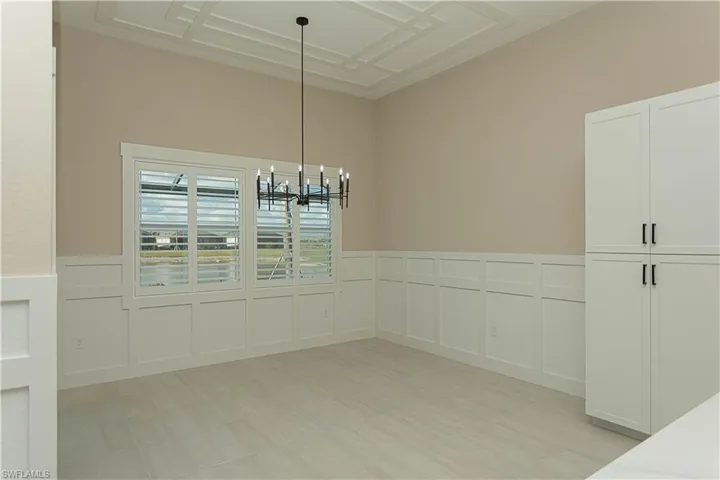 Breakfast nook off kitchen with views of pool/spa/golf course, lake, upgraded decorative ceiling, wainscoting on walls, casing on windows, and upgraded plantation shutters
